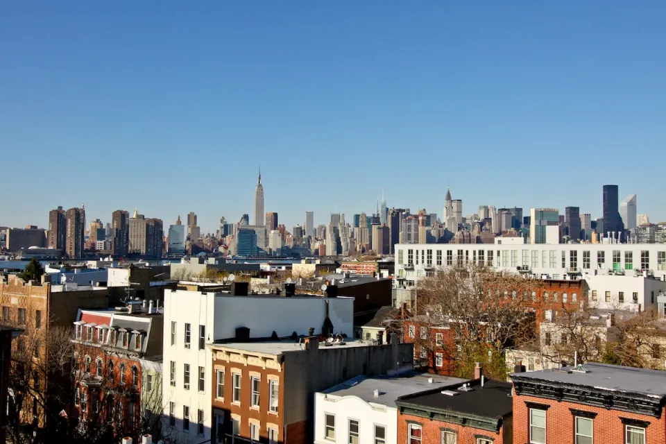 Manhattan skyline seen from Brooklyn, New York City with brick apartment buildings in foreground.